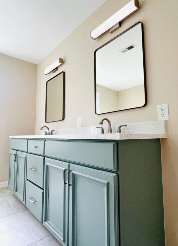 Bathroom interior with green double vanity, quartz countertops, modern lights, and modern mirrors